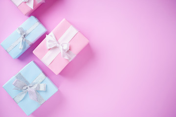 Presents, holiday traditions and shopping. Gift boxes in wrapping paper and tied with satin ribbon on pink background, copy space