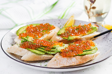 Sandwiches with salmon red caviar with sliced avocado. Sandwich for lunch. Premium food.