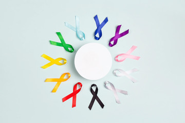 Circle of  colorful awareness ribbons with place for text on blue background. World cancer day concept, February 4.