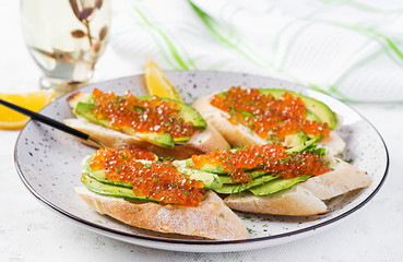 Sandwiches with salmon red caviar with sliced avocado. Sandwich for lunch. Premium food.