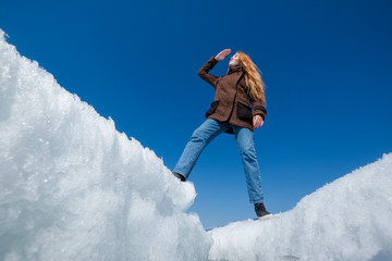 A woman on the background of broken ice covering the lake.