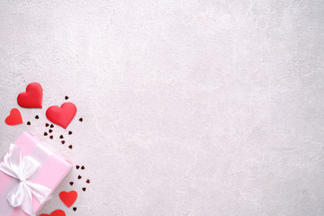 Valentine's, Mother's or Women's Day holidays preparations. presents, celebration concept. composition with gift box and festive heart shaped decorations on stone background