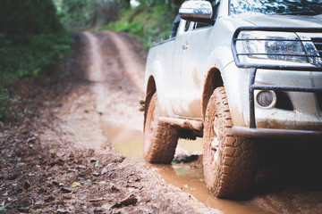  Dirty offroad car, SUV covered with mud on countryside road, Off-road tires,  offroad travel  and driving concept. © Tinnakorn
