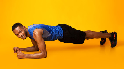 Fit afro sportsman doing plank core exercise