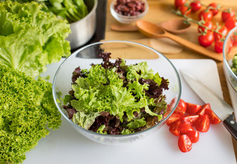 Glass bowl with fresh salad on the kitchen table