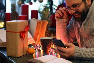 beard man writing christmas gifts on a table