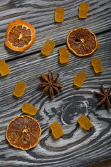 Jelly chewing sweets. Dried slices of orange and anise stars. Scattered on brushed pine boards painted in black and white.