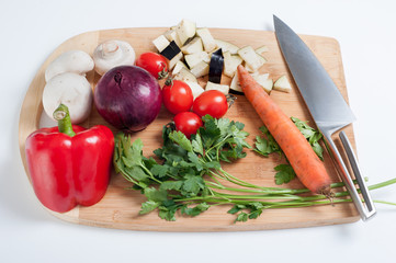 board with sliced vegetables, carrots, mushrooms, parsley, pepper, eggplant, onion. Raw vegetarian healthy food