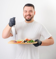 man- chef cutting with smile take knife and vegetables slicing on blackboard