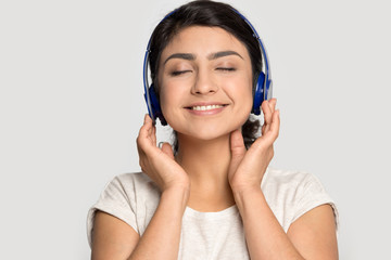 Fototapeta premium Happy smiling indian ethnicity girl enjoying favorite music tracks.
