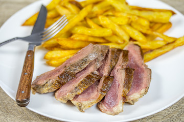 magret de canard et frites dans une assiette