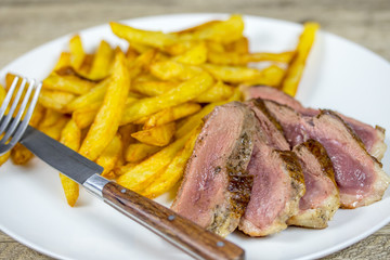 magret de canard et frites dans une assiette