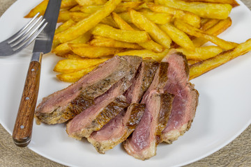 magret de canard et frites dans une assiette