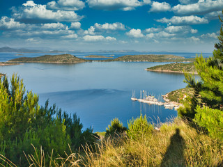 Landscape in Croatia, island archipelago with blue sky, pine tree and sail boat yacht, holiday vacation destination