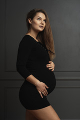 Portrait gorgeous young pregnant woman touching gently with hands her belly, she is waiting a new life