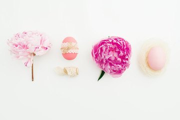 Ester day festive composition with eggs, pink peonies flowers on white background. Flat lay