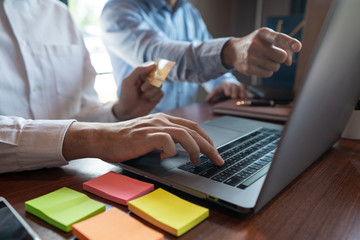 Online shopping credit card data security concept, Hands holding credit card and using smart phone or laptop to shopping or making online payment.