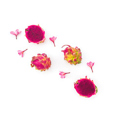 Fruit composition with dragon fruits and pink flowers on white. Flat lay, top view.