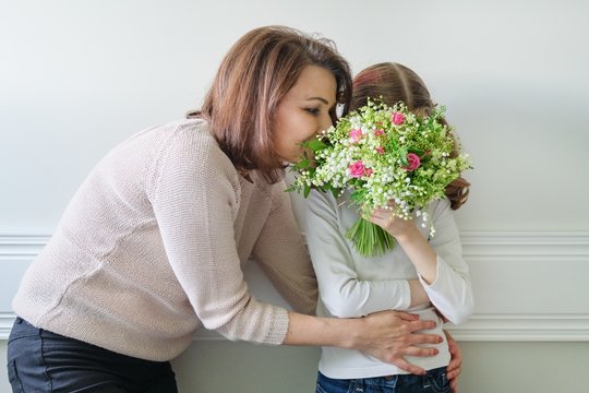 Daughter congratulating mom on beautiful spring flowers on mothers day