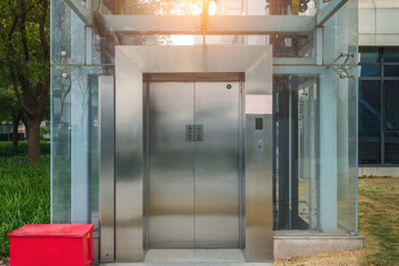 Modern elevator or lift with closed metal door in public park