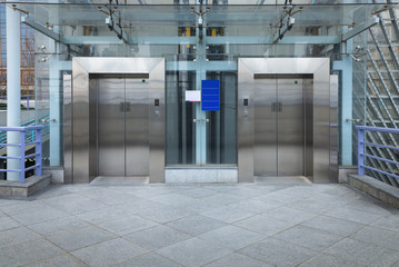 Two modern elevator or lift with closed metal door in public park - obrazy, fototapety, plakaty