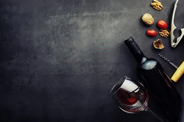 Fotobehang Wijnglas en zwarte wijnfles. Notenkaas en tomaten voor snack. © alexkich