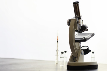 Research laboratory. Test tubes and microscope on the table on a white background.