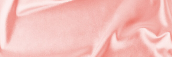 Obraz na płótnie Canvas Light pink silk background with a folds. Abstract texture of rippled satin surface, long banner