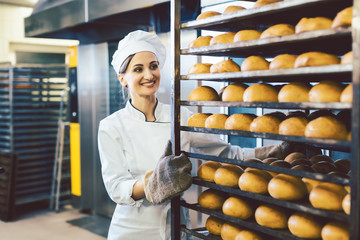 Baker rolling trays with fresh bread thru the bakery