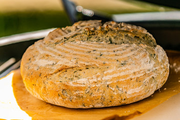 Closeup details of fresh baked bread. Loaf of fresh bread on wooden surface