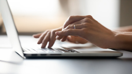 Fototapeta na wymiar Close up of woman typing message on keyboard