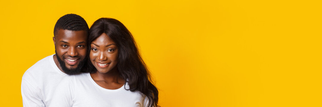 Portrait Of Happily Married Black Couple Posing Over Yellow Background