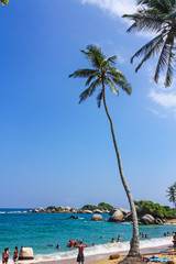 People in Caribbean beach with tropical forest in Tayrona National Park, Colombia. Tayrona National Park is located in the Caribbean Region in Colombia. © Toniflap