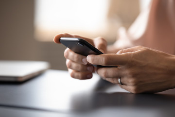 Close up of woman using browsing modern smartphone