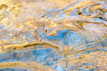 Different shapes and textures of colors made in the water of a river