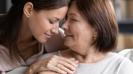 Caring senior mom and adult daughter hugging