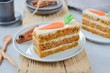 Carrot Cake Day.  National holiday. Carrot cake with cream cheese frosting decorated with chocolate carrots on a light wooden background. Close-up, top view .