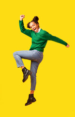 Carefree black girl jumps over yellow background