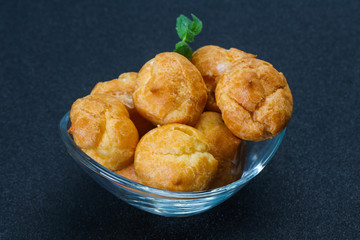 Sweet tasty profiteroles heap in the bowl