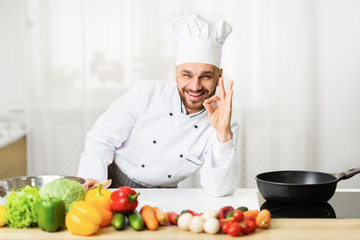 Positive Chef Man Gesturing Okay Standing In Kitchen Indoor