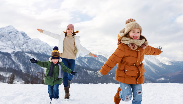 Happy Family Mother And Children Having Fun On Winter Walk