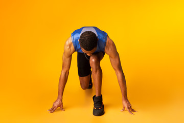 Afro sportsman preparing for a run at studio