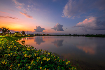 Naklejka premium The blurred abstract background of the colorful twilight evening sky near the large lake, with cool breezes while sitting or exercising in the park.