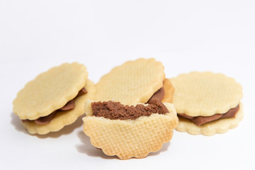 sandwich white biscuits with brown cream on white background