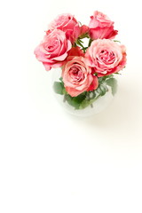 Beautiful pink roses bouquet in a  vase isolated on white background top view, copy space. Home interiour. Pastel colors