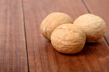 Ripe walnuts close-up on a brown wooden table