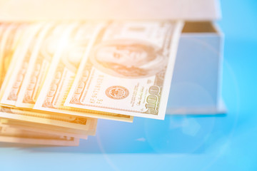 Dollars in a box in the sunlight. Dollars in a box in the sunlight. Open box with dollars toned