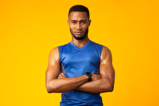 Afro sportsman with folded arms at studio