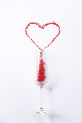 heart shaped candies spilled out of the glass on a white background