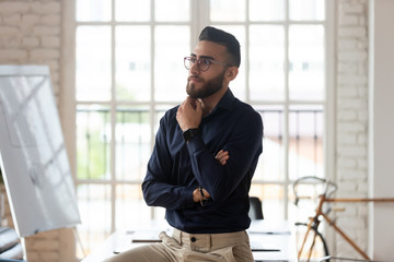 Pensive Arabic male employee thinking making decision